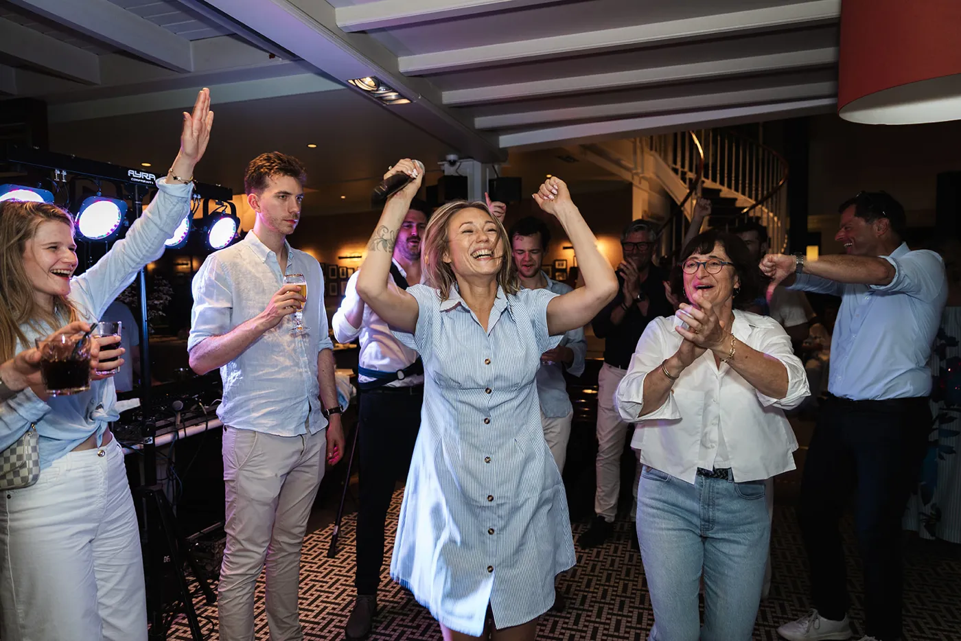 Amber Verleyen zingt tussen de gasten op een feest